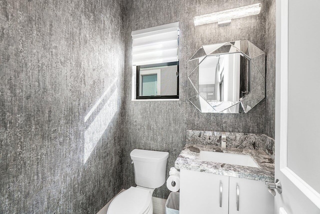 bathroom featuring tile walls, vanity, and toilet