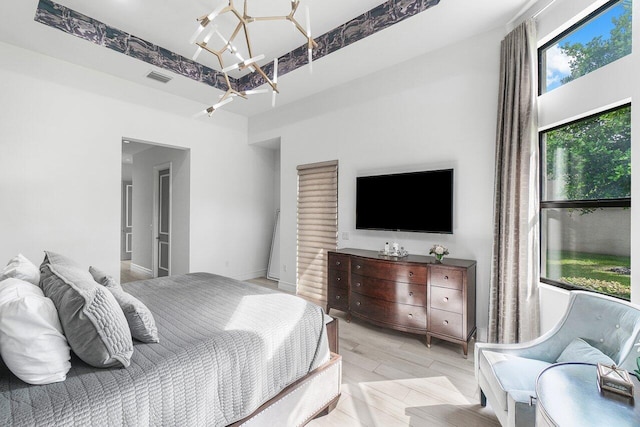 bedroom with an inviting chandelier and light wood-type flooring