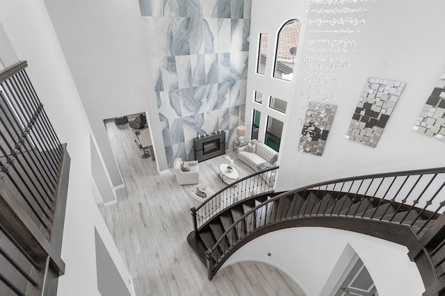 staircase featuring a notable chandelier, a high ceiling, and hardwood / wood-style floors