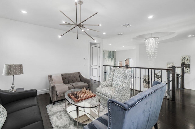 living room with dark wood-type flooring and a notable chandelier