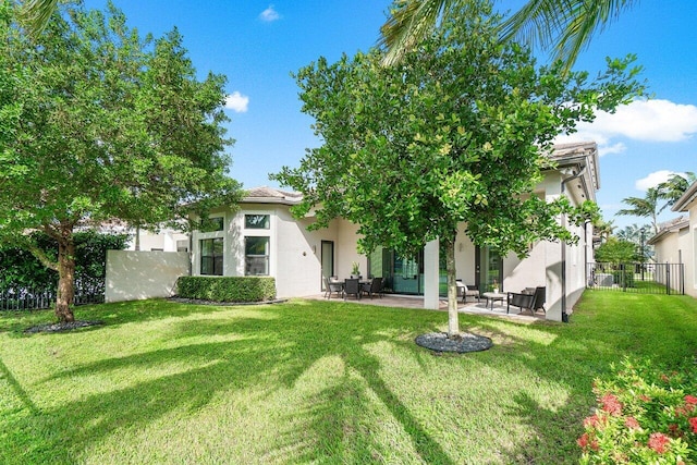 back of house with a patio area and a lawn