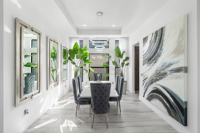 dining room with light hardwood / wood-style flooring and an inviting chandelier