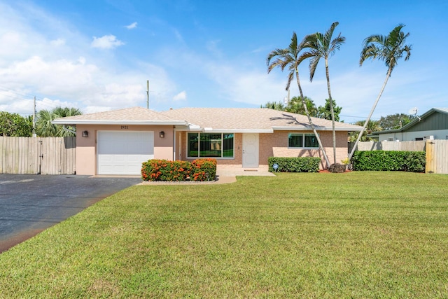 single story home featuring a garage and a front lawn