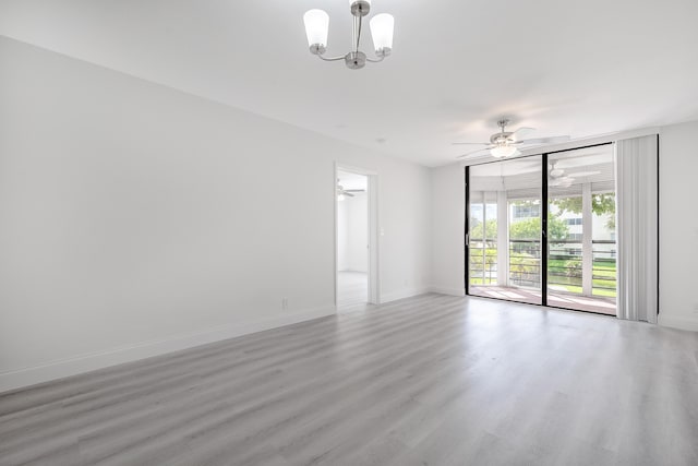 empty room with wood-type flooring and ceiling fan with notable chandelier