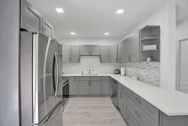 kitchen featuring tasteful backsplash, sink, and gray cabinetry