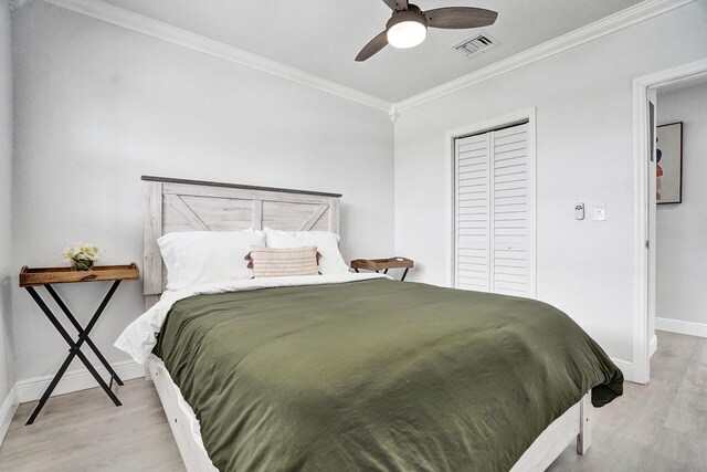 bedroom featuring ceiling fan, ornamental molding, multiple windows, and light wood-type flooring