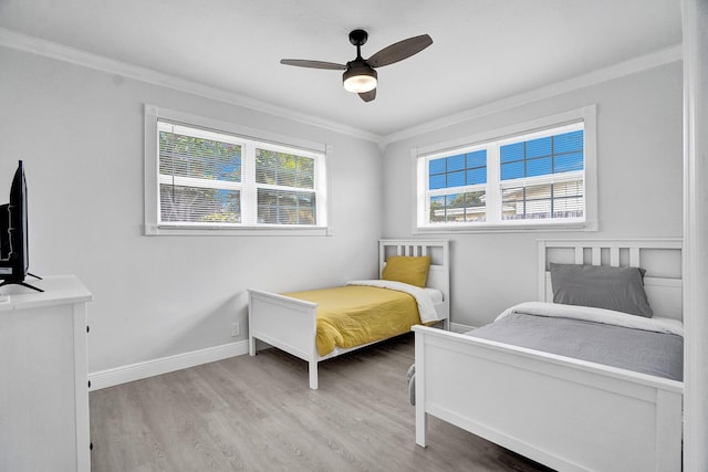 bedroom with light hardwood / wood-style flooring, ornamental molding, and ceiling fan