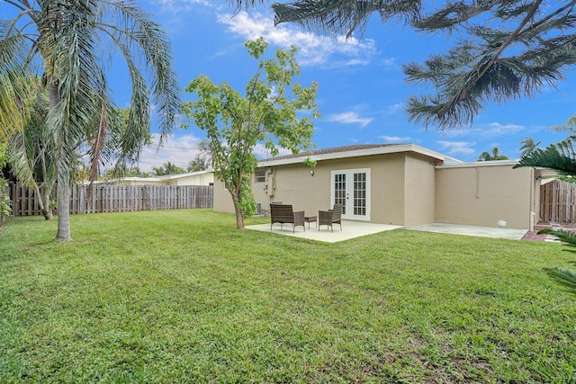 back of property featuring french doors, a yard, and a patio area