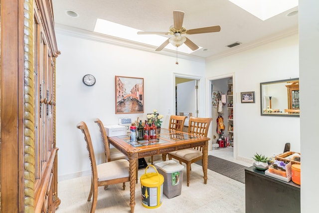 dining room featuring a skylight, ceiling fan, and crown molding