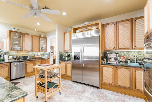 kitchen with ceiling fan, light tile patterned flooring, appliances with stainless steel finishes, and tasteful backsplash