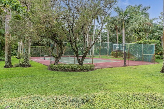 view of sport court with tennis court and a lawn