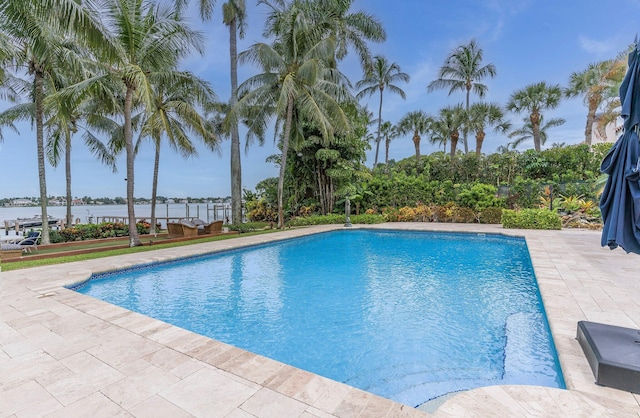 view of pool with a patio area and a water view