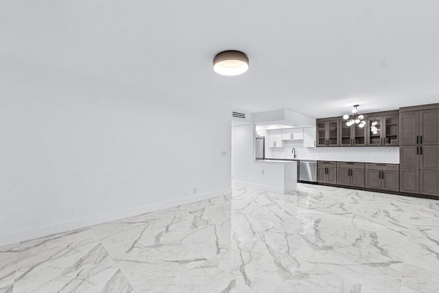 unfurnished living room with sink and an inviting chandelier