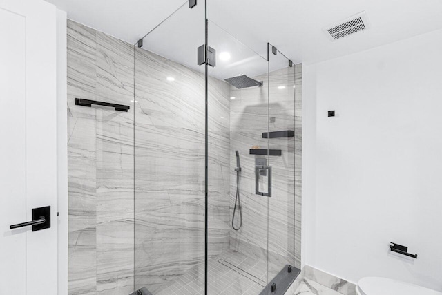 bathroom with toilet and a shower with shower door