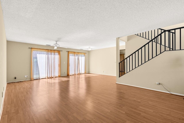 unfurnished living room with ceiling fan, wood-type flooring, and a textured ceiling