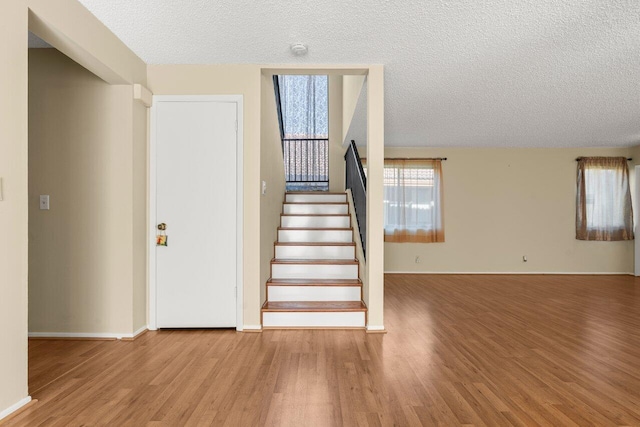 stairway featuring hardwood / wood-style floors and a textured ceiling