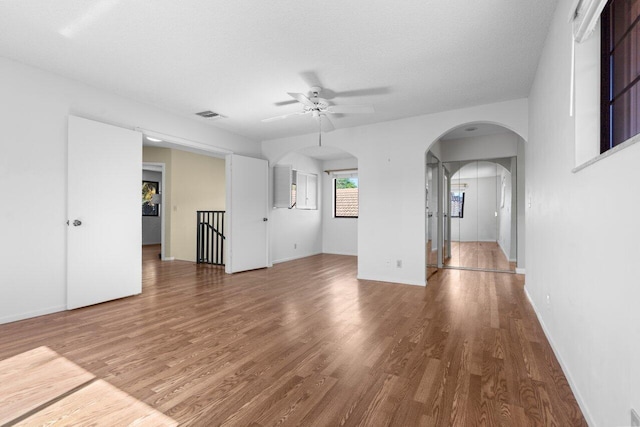 unfurnished living room with hardwood / wood-style flooring, a textured ceiling, and ceiling fan