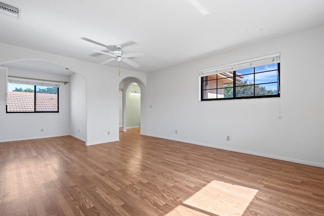 empty room featuring a textured ceiling, ceiling fan, and light hardwood / wood-style flooring