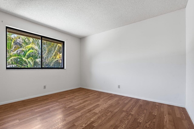 spare room featuring hardwood / wood-style flooring and a textured ceiling