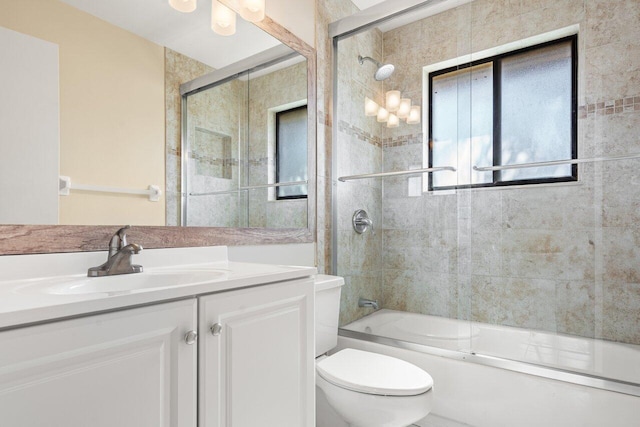 full bathroom featuring vanity, bath / shower combo with glass door, and toilet