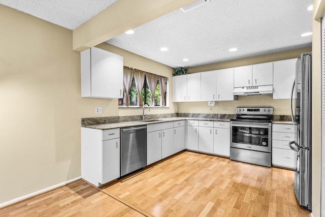 kitchen featuring sink, light hardwood / wood-style flooring, stainless steel appliances, a textured ceiling, and white cabinets