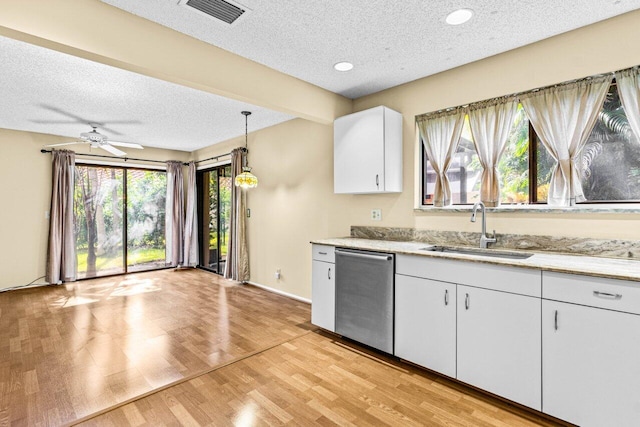 kitchen featuring sink, decorative light fixtures, light wood-type flooring, dishwasher, and white cabinets