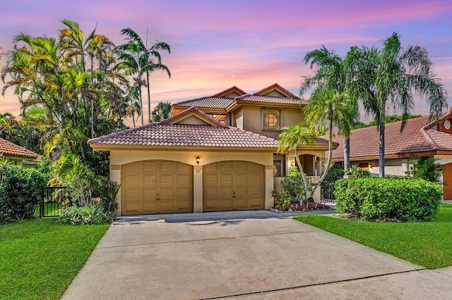 mediterranean / spanish-style home featuring a garage and a lawn