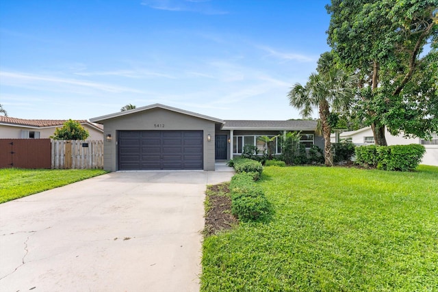 ranch-style home featuring a garage and a front lawn