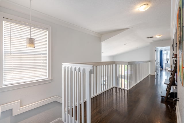 hall with lofted ceiling, dark wood-type flooring, a textured ceiling, and ornamental molding