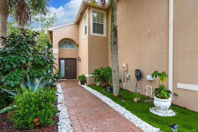 view of exterior entry featuring a yard