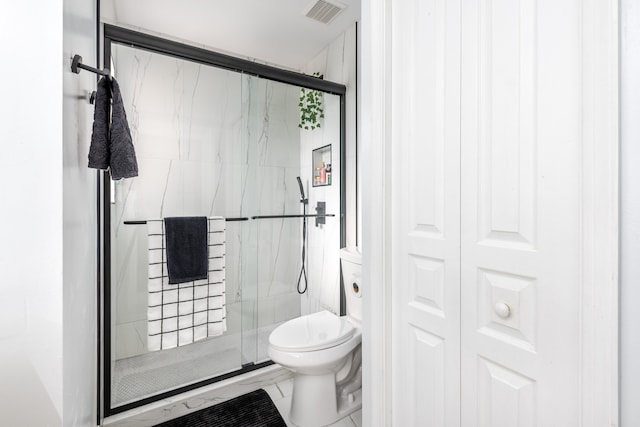 bathroom with a shower with shower door and toilet