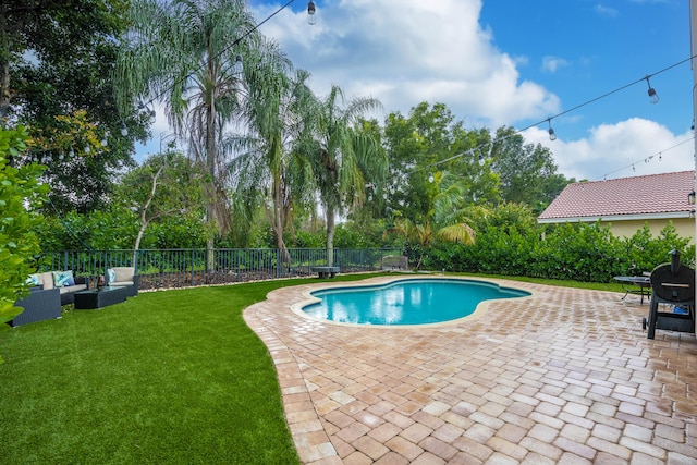 view of pool with a patio, area for grilling, outdoor lounge area, and a yard