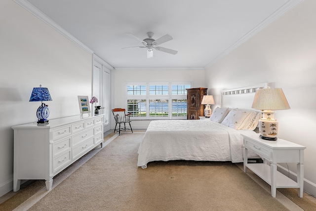 carpeted bedroom featuring crown molding and ceiling fan