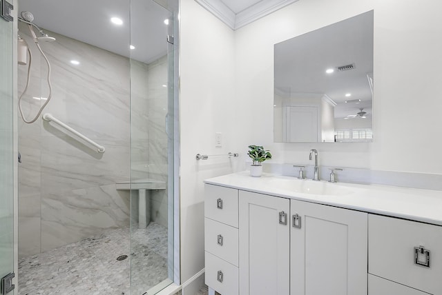 bathroom featuring a shower with door, ornamental molding, vanity, and ceiling fan