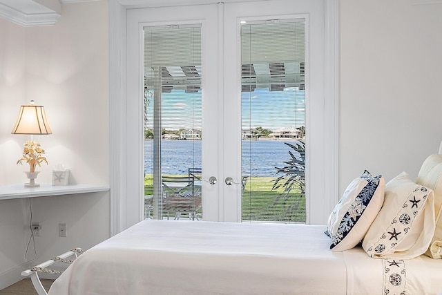 bedroom featuring a water view, french doors, and access to outside