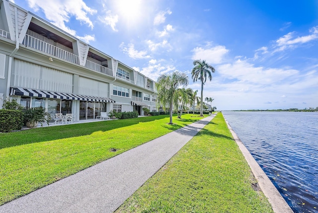 view of home's community with a yard and a water view