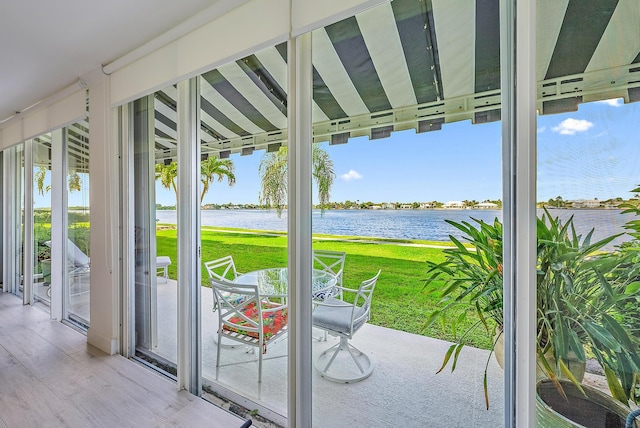 doorway to outside with hardwood / wood-style floors and a water view