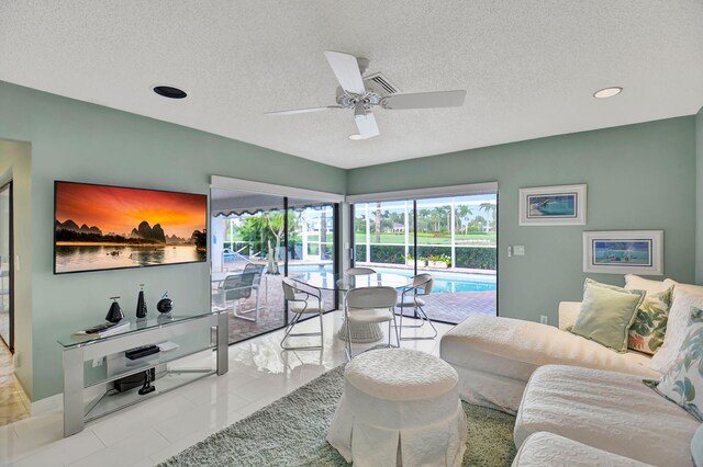 tiled living room featuring ceiling fan and a textured ceiling