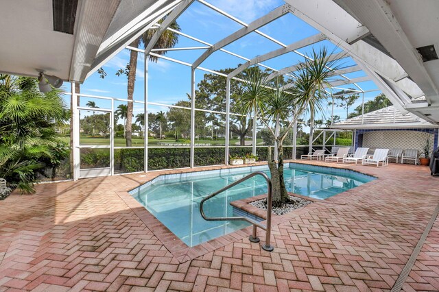 view of swimming pool featuring a lanai, area for grilling, and a patio area