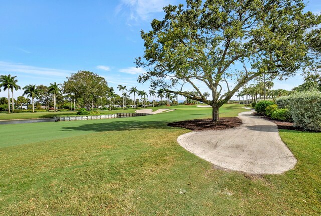 view of property's community with a lawn and a water view