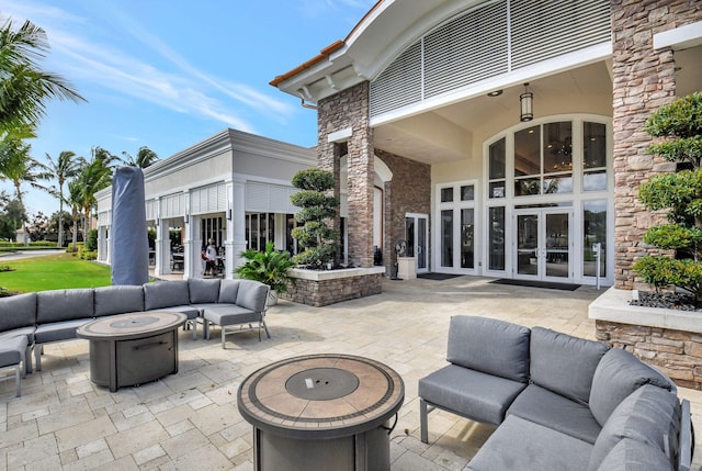 view of patio / terrace with french doors and an outdoor living space with a fire pit