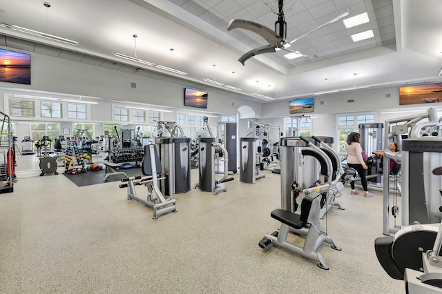 gym with a towering ceiling and ceiling fan