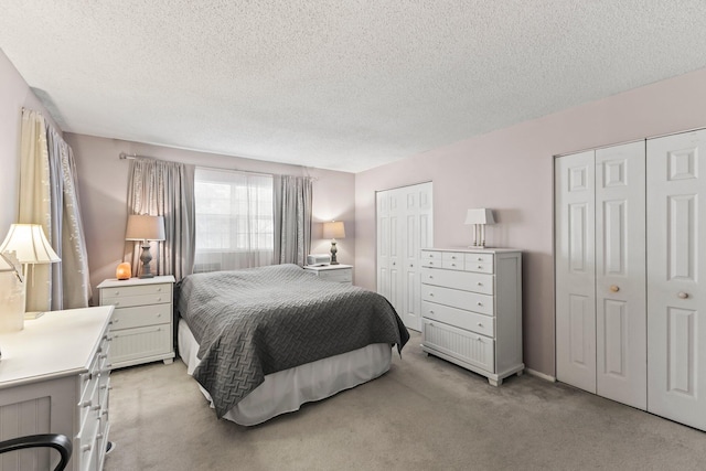 2950 SE Ocean Blvd Unit 38-2, Stuart, FL 34996 - bedroom with a textured ceiling, multiple closets, and light carpet