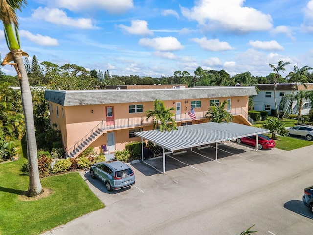 2950 SE Ocean Blvd Unit 38-2, Stuart, FL 34996 - view of building exterior with covered and uncovered parking and stairs