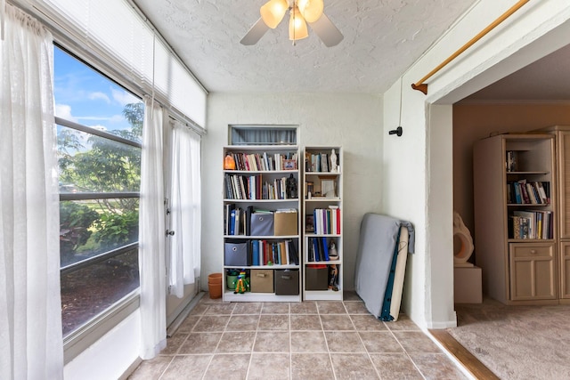 sitting room with ceiling fan, crown molding, a textured ceiling, and light tile patterned flooring