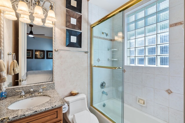 full bathroom with vanity, toilet, shower / bath combination with glass door, and ceiling fan