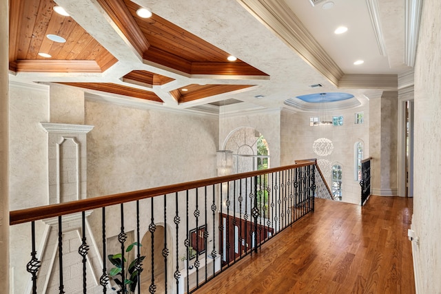 hallway featuring a chandelier, ornamental molding, hardwood / wood-style floors, and coffered ceiling