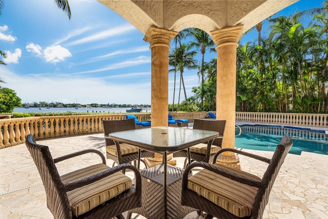 view of patio with a water view and a fenced in pool