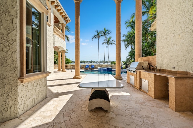 view of patio with sink, exterior kitchen, and a grill