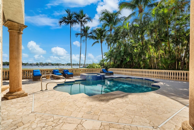 view of swimming pool featuring a patio area, an in ground hot tub, and a water view